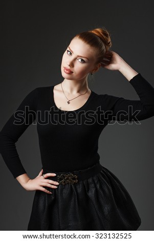 Portrait of a young beautiful girl in black clothing on a black background in the studio. Woman dancer or ballerina.