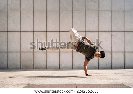 Similar – Image, Stock Photo Man doing acrobatic in the beach. Moody weather and rain