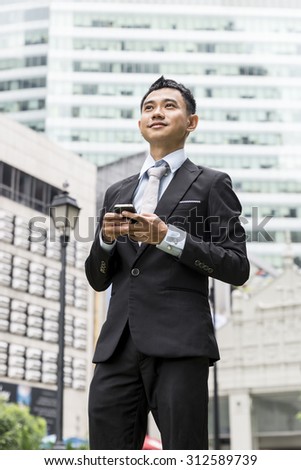 handsome business man writing email or message on phone, model is a asian male