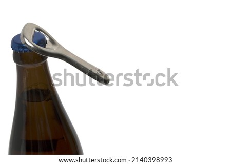 Close up silver retro vintage bottle opener that opens the crown cap of a brown beer bottle on white background ストックフォト © 