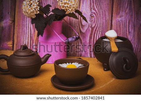 Art still life. Composition-clay teapot and cups. Beautiful flowers