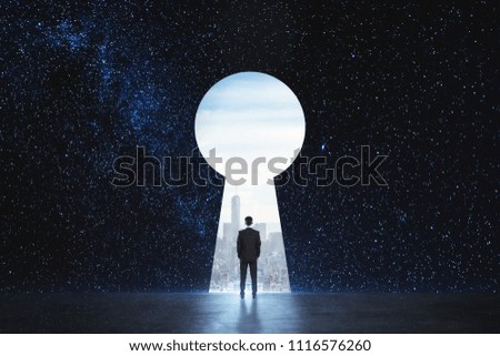 Back view of young businessman standing against keyhole door on starry sky background. Dream, success, opportunity and startup concept