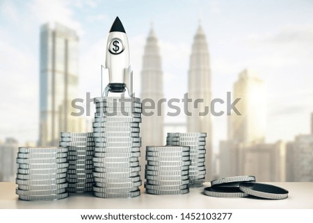Abstract dollar rocket on silver coins stack. Blurry Kuala Lumpur city background. Startup and venture capital concept. 3D Rendering  ストックフォト © 