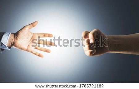 Two hands fist and palm on gray background. Business and challenge concept. Close up