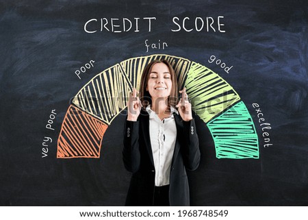 Bank loan concept with businesswoman crossing her fingers on blackboard background with credit score scale