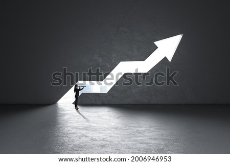 Businesswoman with telescope looking at glowing city view opening growing upward arrow in concrete interior. Success, future, achievement and growth concept