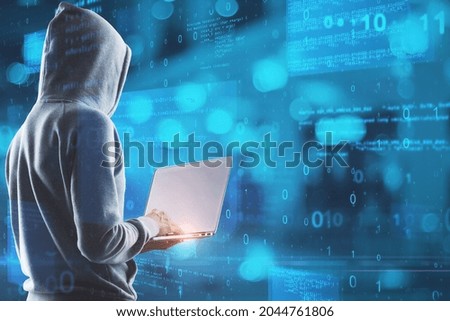 Hacker in hoodie using laptop with abstract glowing blue coding background. Binary code, theft, technology, data and internet concept. Double exposure