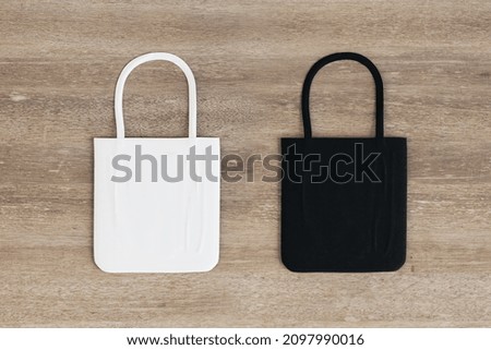 Top view and close up of empty black and white shoppers on wooden surface background. Mock up, advertisement, 3D Rendering