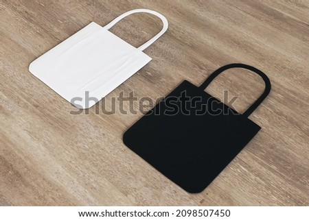 Top view and close up of blank black and white shoppers on wooden surface background. Mock up, advertisement, 3D Rendering