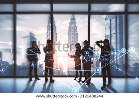 Businesspeople working together in contemporary office with abstract glowing polygonal network with people icons and blurry city view. Online networking, multimedia, digital communication concept. 