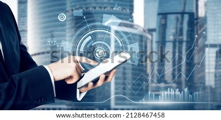 Close up of businessman hand pointing at tablet with abstract digital business interface on blurry city background background. Technology, finance, success, economy and growth concept. Double exposure