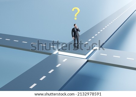 Attractive young european businessman standing at crossroads with question. Solution, way and direction concept