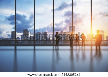 Backlit crowd of businesspeople working together in bright office interior with sunlight and city view with clouds. Teamwork and corporate workplace concept. Double exposure