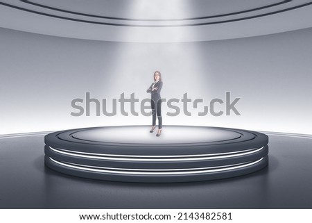 Thoughtful young businesswoman standing in abstract light round pedestal interior with spotlight