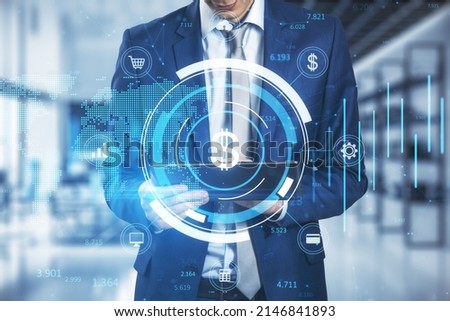 Close up of businessman hand holding tablet with creative glowing round dollar chart hologram on blurry office interior workplace background. Currency, finance and online banking concept. 