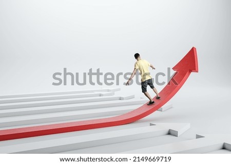 Back view of casual young man balancing on growing red arrow on light background. Improving business and changing direction concept