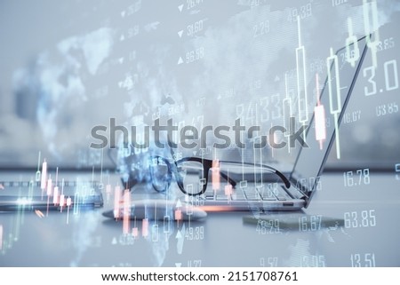 Global trading and stock market concept with foggy digital interface with world map and forex market indicators and candlesticks on office workplace background with laptop and glasses