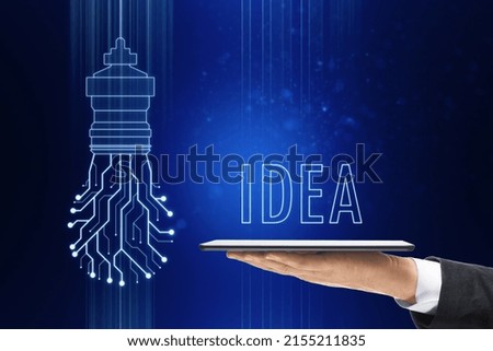 Close up of businessman hand holding tablet with abstract glowing circuit light bulb on blue background. Future, innovation and solution concept