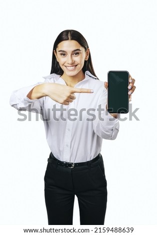 Mobile application concept with happy girl in white shirt showing modern smartphone with blank screen isolated on light background, mockup