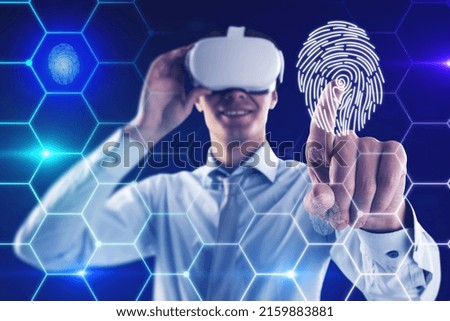 Attractive young european man with VR glasses on blue background with digital thumb print biometrics hexagonal hologram. Virtual reality, access and experience concept. Double exposure