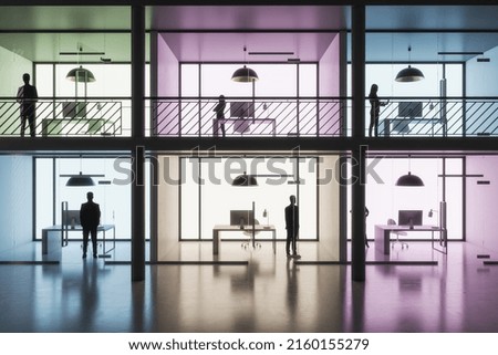 Front view on coworking area with separated by colorful walls parlors with minimalistic workspaces and people inside