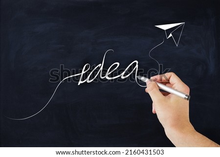 Business strategy, soft skills and creative idea concept with man hand writing on blackboard idea word