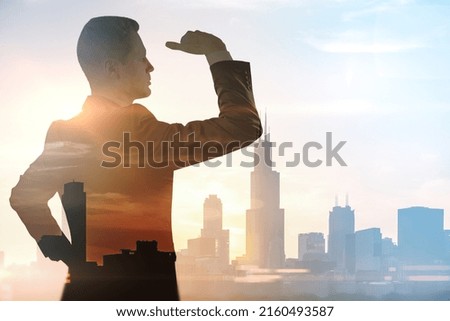 Look into the future and business development concept with handsome man silhouette looking at the horizon on city background on sunset, double exposure