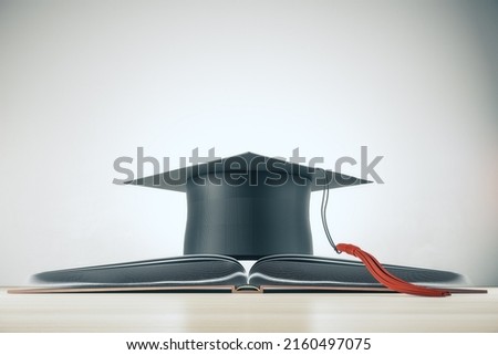 Higher education and study concept with black mortarboard hat on opened book on light background. 3D rendering 商業照片 © 