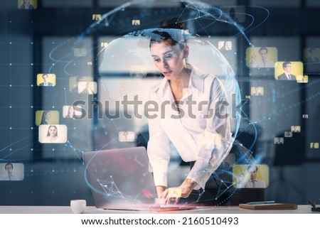Business society and networking concept with young businesswoman using laptop on the table and virtual screen with digital world map globe and people profile pictures she contacted