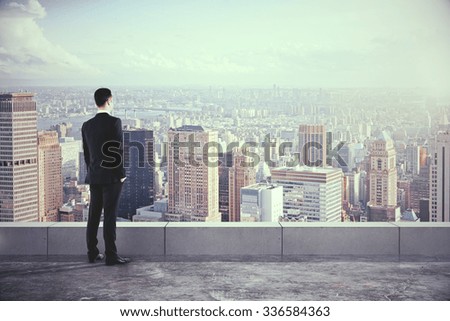 Empresario en la azotea y mirando a la ciudad con rascacielos