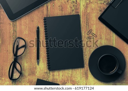 Top view of wooden office table with black notepad, coffee cup, pen, glasses, clips, tablets and other items. Workplace concept. Mock up, 3D Rendering