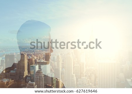 Silhouette of young male on abstract city background with copy space and sunlight. Double exposure
