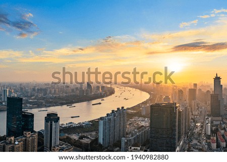 Aerial view of modern city skyline and buildings at sunrise in Shanghai.
