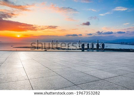 Empty square floor and modern city skyline with sea in Hainan.