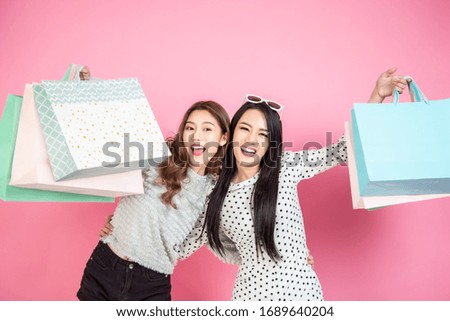 happy asia beautiful smiley woman holding shopping bag with pink background
