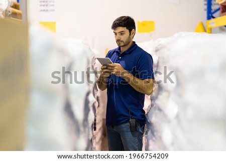 Warehouse male worker using digital tablet checking products or parcel goods in industry factory warehouse. Inspection quality control