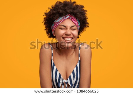 Similar – Image, Stock Photo Photo of delighted curly woman keeps both hands on waist, smiles gently, has slim figure, wears white t shirt and black jeans, being in good mood, stands self assured against white background