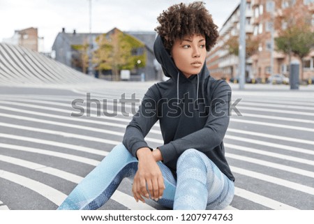 Similar – Image, Stock Photo Serious black sportswoman sitting on stone border in city