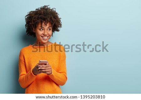 Similar – Image, Stock Photo Photo of delighted curly woman keeps both hands on waist, smiles gently, has slim figure, wears white t shirt and black jeans, being in good mood, stands self assured against white background