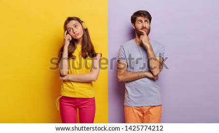 Thouhtful woman and man do not look at each other, being in deep thoughts, dream about future vacation, female listens pleasant melody in headphones, enjoys spare time. People and doubt concept