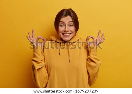 Similar – Image, Stock Photo Woman in yellow hoodie taking selfie on smartphone on rocky shore