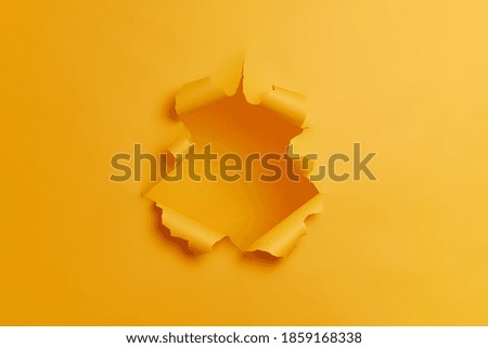 Big paper hole in center of yellow background. Blank space to insert your advertising content promotion or text information. Torn ripped studio wall. Breakthrough concept. No people in shot. Imagine de stoc © 