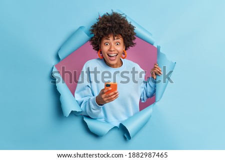 Similar – Image, Stock Photo Photo of delighted curly woman keeps both hands on waist, smiles gently, has slim figure, wears white t shirt and black jeans, being in good mood, stands self assured against white background