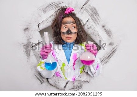 Similar – Image, Stock Photo Serious chemist examining liquid in flask in lab