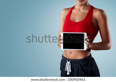 fitness, dieting, technology and sport concept - sporty mixed race woman showing tablet pc blank black screen over isolated backround