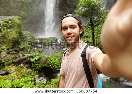 Similar – Image, Stock Photo Young man recording himself while playing guitar and singing to share the video in social media. Musician recording a music video at home.