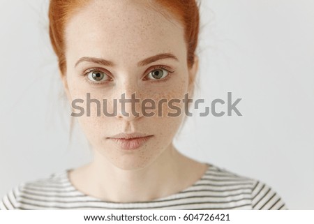Close up highly-detailed portrait of amazing charming young European woman with ginger hair and perfect healthy freckled skin, wearing striped t-shirt, looking at camera with pretty cute smile
