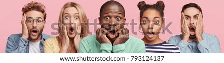 Shocked stupefied dark skinned man and their companions pose against pink background. Emotional surprised horrified mixed race people see something unexpected in front. Human reaction concept