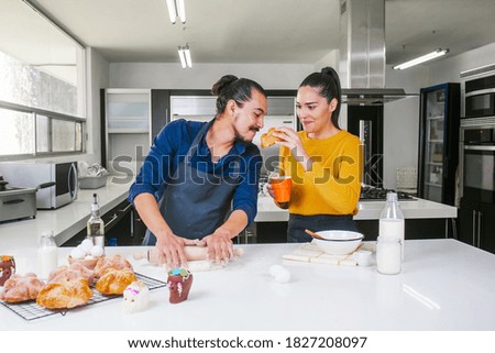 Mexican couple baking and eating bread called pan de muerto traditional from Mexico in Halloween