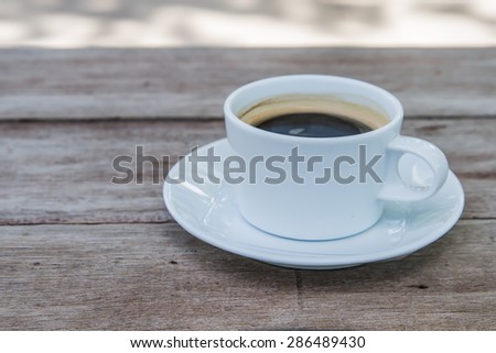 White Coffee Mug shot close to right on a wooden table.